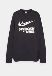 Sweat-shirt noir à manches longues avec deux logos Nike Swoosh blancs et le texte "SWOOSH BY NIKE" imprimé sur le devant.