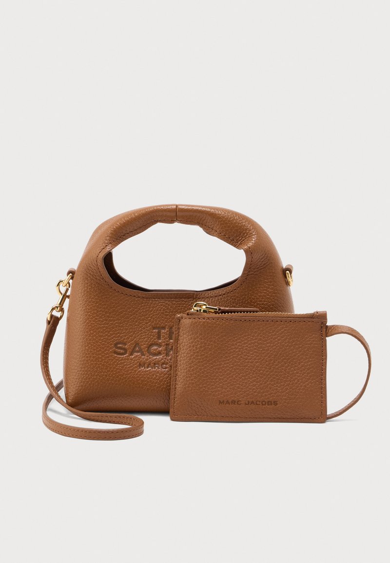 Καφέ δερμάτινη τσάντα με στρογγυλεμένη λαβή, με ανάγλυφο λογότυπο. Περιλαμβάνει ταυτόχρονη θήκη καρτών με κλείσιμο φερμουάρ.