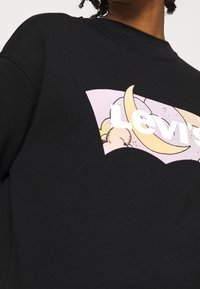 Felpa nera con un design grafico che presenta un'etichetta viola chiaro e una luna crescente. Tessuto morbido, collo rotondo e vestibilità rilassata.