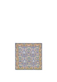 Pañuelo de seda con patrón floral multicolor que presenta diseños intrincados en azul, verde y naranja, con un borde con flecos.