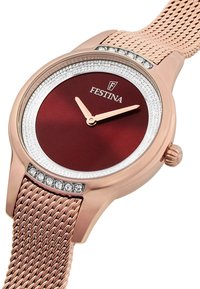 Montre bracelet en or rose avec un cadran bordeaux, des accents argentés et des pierres décoratives. Comprend un bracelet en maille et une lunette texturée.