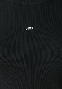 Crni pletivni top s visokim izrezom i malim bijelim logotipom "JJXX" ušivenim sprijeda. Glatka tekstura, prilagođen oblik.