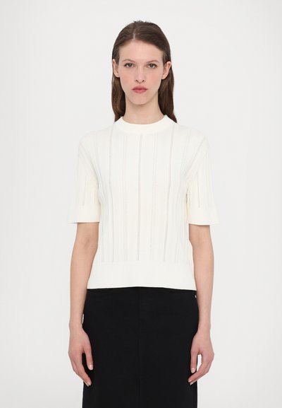 White knitted short-sleeve sweater with vertical ribbed texture and a round neckline, paired with a black skirt.
