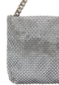 Sølv mesh håndtaske med hexagonal mønster, metallisk glans og en kædetraspe. Har en glat overflade og reflekterende detaljer.