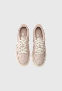 Lyserøde Nike joggesko med snøredesign, perforert tå, off-white detaljer og gummisåle. Glatt tekstur med merkevare på tunga.