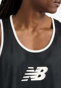 Black mesh athletic tank top with a white neckline trim and white New Balance logo on the front, featuring a breathable texture.