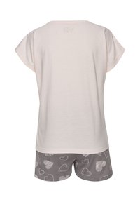 Gaiši rozā īsām piedurknēm tops ar mīkstu tekstūru. Pelēkas šortus ar baltām sirdīšu rakstiem. Ikdienišķs, ērts pelējuma apģērba komplekts.