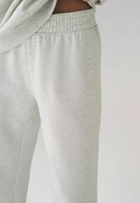 Helle graue Sweatpants aus weichem, strukturiertem Stoff. Mit elastischem Bund und seitlichen Nähten für eine entspannte Passform.