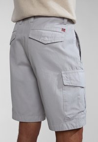 Pantalones cortos cargo gris claro hechos de algodón con un corte regular. Presentan bolsillos laterales, solapas traseras y un pequeño acento de la bandera noruega.