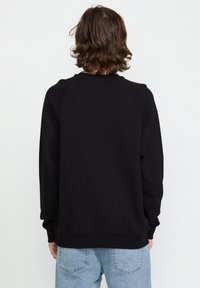 Zwarte crewneck sweatshirt met lange mouwen, textuurstof, geribbelde boorden en onderrand, met een eenvoudig ontwerp zonder grafische elementen.