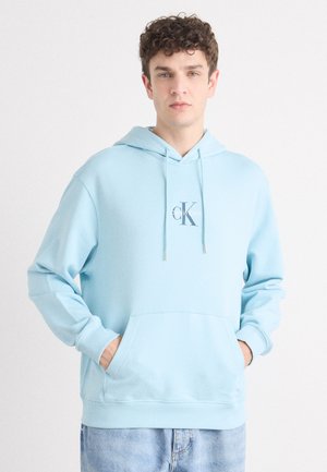 Hellblauer Hoodie mit einer Fronttasche, Kapuze mit Kordelzug und besticktem "CK"-Logo. Aus weichem Material gefertigt, mit gerippten Bündchen und Saum.