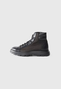 Stivale da trekking nero con un corpo in tessuto nero texturizzato, punta arrotondata, design con lacci e una spessa suola in gomma per la trazione.