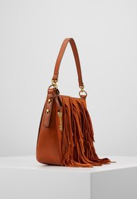 Brązowa skórzana torebka z frędzlami, złotymi akcentami i zawieszką w kształcie klucza. Posiada jeden mocny pasek na ramię.