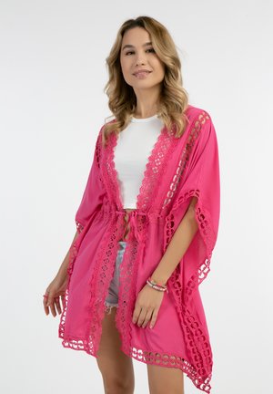 Kevyt vaaleanpunainen kimono pitsireunuksilla, avoin etuosa ja solmittava vyötärö. Sisältää monimutkaisia leikkuukuviota reunoilla ja leveät hihat.