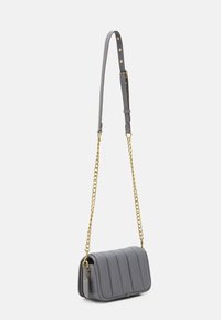Borsa a tracolla grigia in pelle trapuntata con tracolla in metallo dorato e spallaccio in pelle regolabile. Presenta una texture liscia e un'etichetta discreta.