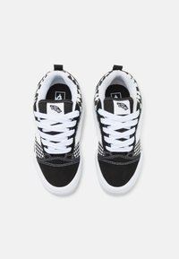 Sneakers in tela bianca e nera con motivo a scacchi, lacci bianchi e collo imbottito. Suola in gomma con dettagli cuciti.