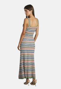 Maxi-jurk met verticale strepen in groen, roze, blauw en crème; zachte gebreide textuur; vierkante halslijn; brede schouderbanden; enkellang.