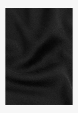 Sort stof med bløde folder og en glat tekstur, der viser subtile lystreflektioner og blide krøller.