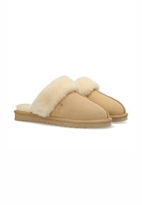 Chaussons en suède beige avec une douce doublure en shearling crème, bout rond et semelle en caoutchouc plate. Présente des coutures contrastantes le long des coutures.