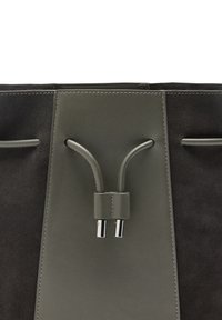 Torba z zamszowej i gładkiej skóry w ciemnoszarym i czarnym kolorze, z centralnym zapięciem na zamek zabezpieczonym srebrnymi elementami i kontrastującymi przeszyciami.