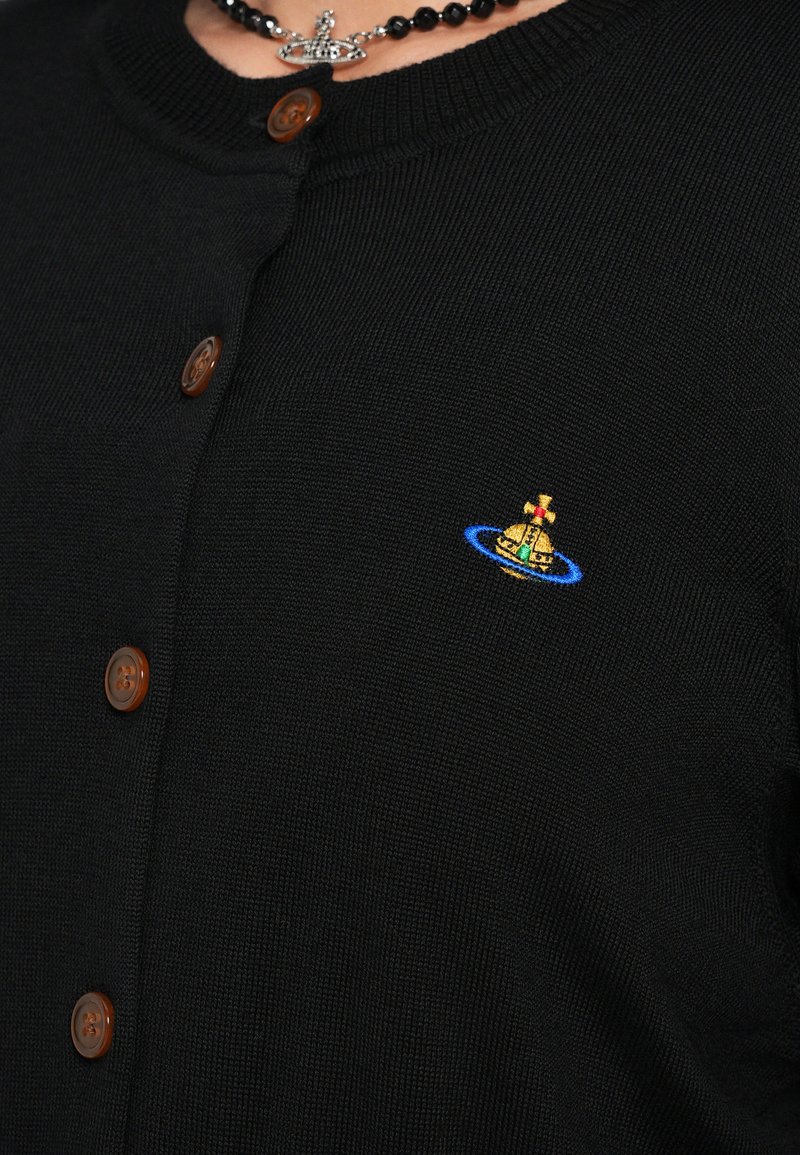 Cardigan nero a maglia con scollatura rotonda, bottoni marroni e piccolo design ricamato a colori con motivo di corona e globo.