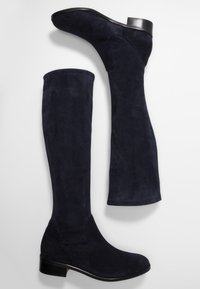 Stivali in suede blu navy al ginocchio con una texture liscia e lucida e un piccolo tacco nero. Progettati con un gambale aderente e punta rotonda.