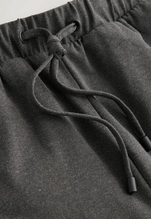 Anthrazitgraue Jogginghose mit Kordelzugbund und schwarzen Kunststoffenden, weichem Stoff und lockerem Schnitt.