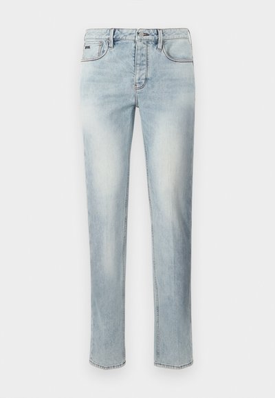 Lyseblå rette jeans med falmede detaljer foran, fem lommer, knappelukking og beltehemper på hvit bakgrunn.