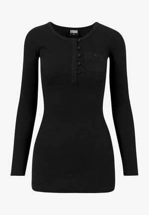 Svart langermet ribbestrikket topp med rund hals, knappestolpe og venstre brystlomme. Stoffet er glatt med en tettsittende fasong.