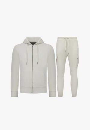 Lichtbeige hoodie met voorrits en trekkoorden, gecombineerd met bijpassende joggerbroek met zijzakken en een verstelbare taille met trekkoord.