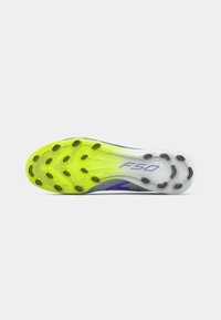 Bottom view of a soccer cleat soleplate with yellow and white gradient, black studs, and "F50" logo in purple on heel.
