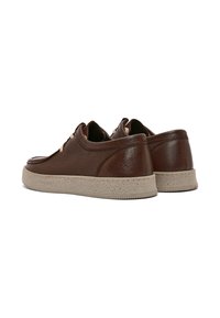 Sneakers in pelle marrone con finitura testurizzata, suola in gomma beige e design classico con lacci e dettagli minimal.