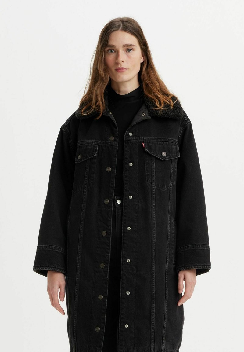 Veste en denim noir avec un col doux et texturé, de grandes poches avant et une fermeture à boutons-pression. Coupe ample avec une coupe droite.