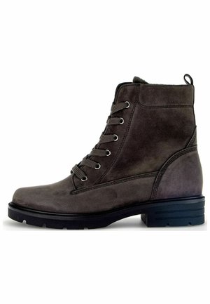 Botte chelsea en suède gris foncé, avec bout rond, œillets en métal, devant à lacets et semelle en caoutchouc noir contrastant. Présente une languette à l'arrière.