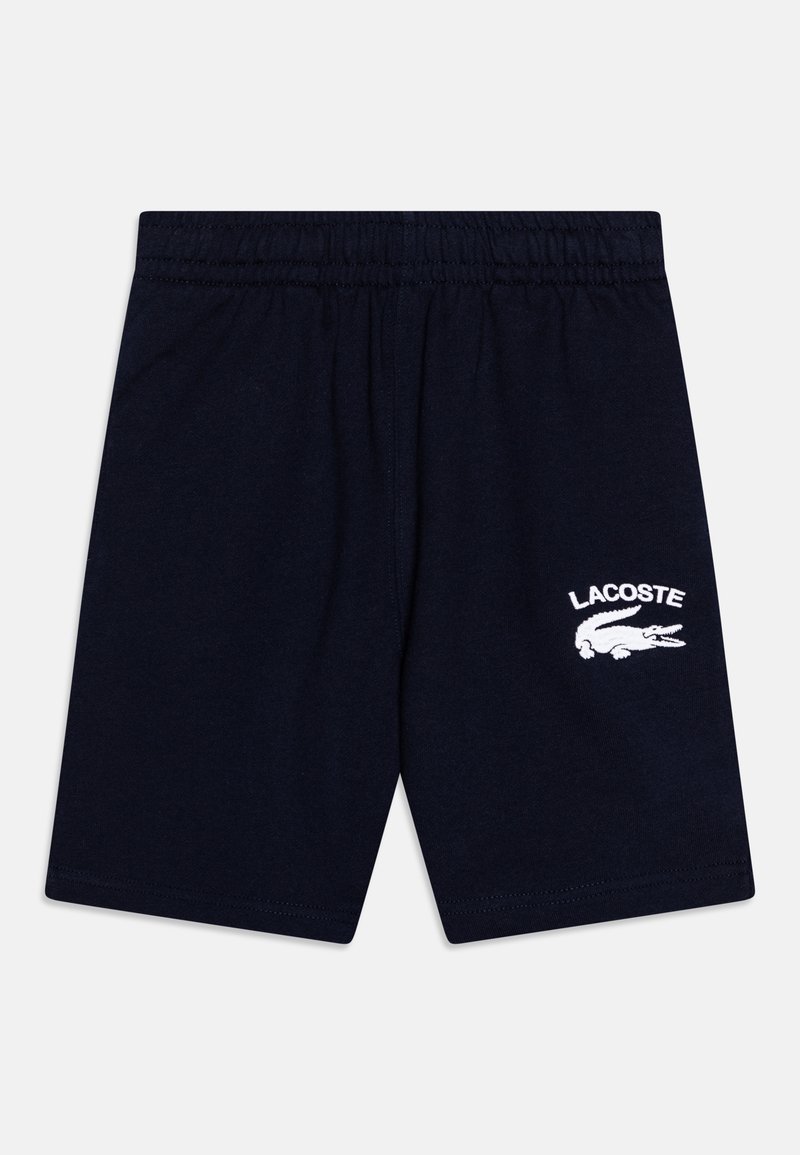 Shorts avec taille élastique bleu marine, logo Lacoste blanc et emblème de crocodile sur la jambe droite.
