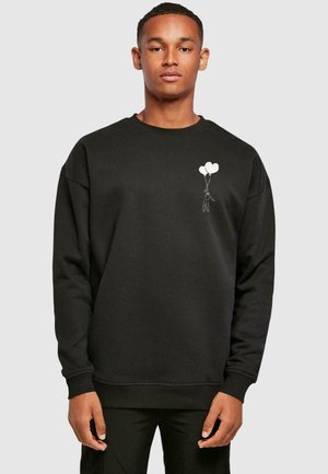 Schwarzer Sweatshirt aus dickem Stoff, mit einem grafischen Motiv einer Figur, die drei herzförmige Ballons auf der linken Brust hält.