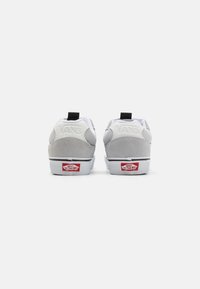 Adidași Vans gri și albi din material din suede, cu un design low-top, tab de călcâi și logo din cauciuc roșu pe talpă. Prezintă detalii de cusătură.