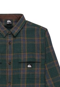 Grün und marineblau karierter Flanellhemd mit braunen Akzenten, ausgestattet mit einem Button-down-Kragen, Brusttaschen und einem Logosticker. Strukturierter Stoff.