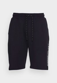 Černé kraťasy vyrobené z měkkého materiálu, s elastickým pasem a šňůrkou, a s bílým potiskem loga na boku.