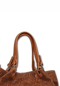 Bruine leren handtas met gegraveerde, kronkelige bloemmotieven en dubbele ronde handvaten met metalen bevestigingen.