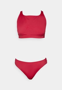 Ensemble bikini rouge comprenant un haut à encolure carrée avec de larges bretelles et un bas taille basse assorti, fabriqué dans un matériau lisse et élastique.