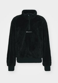 Sort fleece-pullover med høj krave, halv-lynlås, elastiske manchetter og et lille hvidt logo foran. Blød tekstur hele vejen igennem.