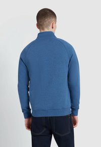 Blue pullover sweatshirt with a high collar, ribbed cuffs and hem, made from textured fabric, featuring raglan sleeves and a smooth finish.