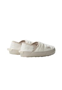 Chaussures à enfiler matelassées beige clair avec une texture douce, dotées d'une semelle en caoutchouc et de poign�ées au talon pour un enfilage facile.
