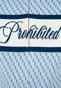 Tissu tricoté bleu et blanc avec le mot « Interdit » en italique au centre, présentant un motif de petits rectangles.