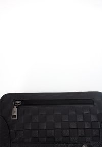 Clutch in pelle nera con texture intrecciata, tasca frontale con zip e bordi lisci. Inclusi accenti in hardware nero opaco.