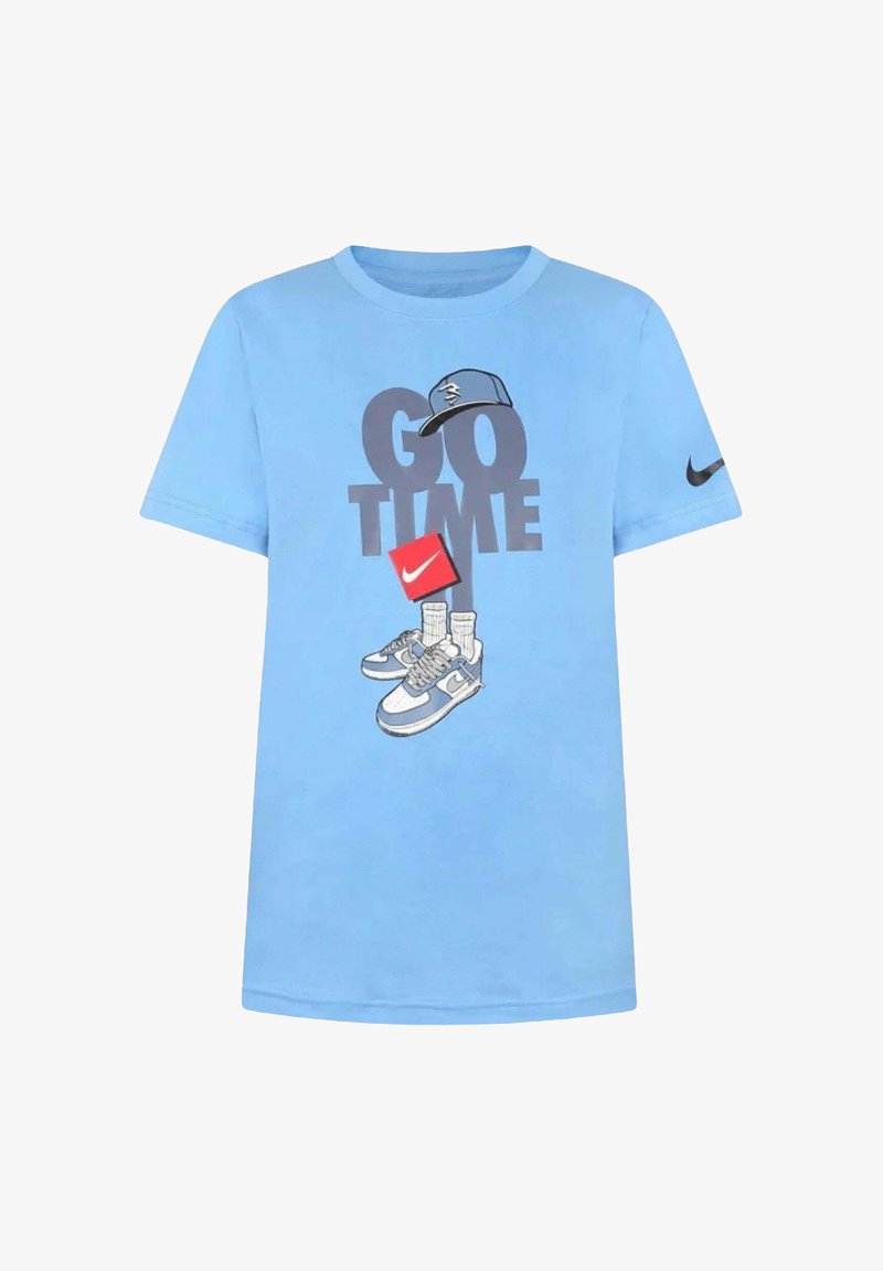 T-shirt di cotone azzurro chiaro con stampa grafica di sneakers, un cappellino e il testo "GO TIME" in grigio scuro, con logo Nike nero sulla manica.