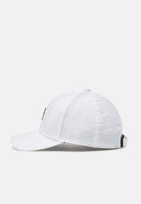 Hvid baseballkasket med en buet skygge, struktureret front og justerbar rem bagpå. Inkluderer ventilationshuller og et tekstureret stof.