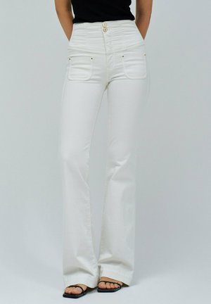 Jeans acampanados blancos hechos de una tela ligera, con una cintura alta, dos bolsillos frontales y tres botones decorativos en la parte superior.