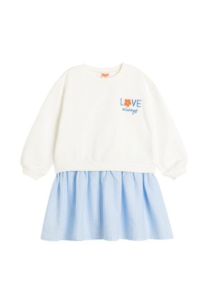 Hvid langærmet top med teksten "LOVE always" og orange blomst over et blåt og hvidt lodret stribet rynket skørt.